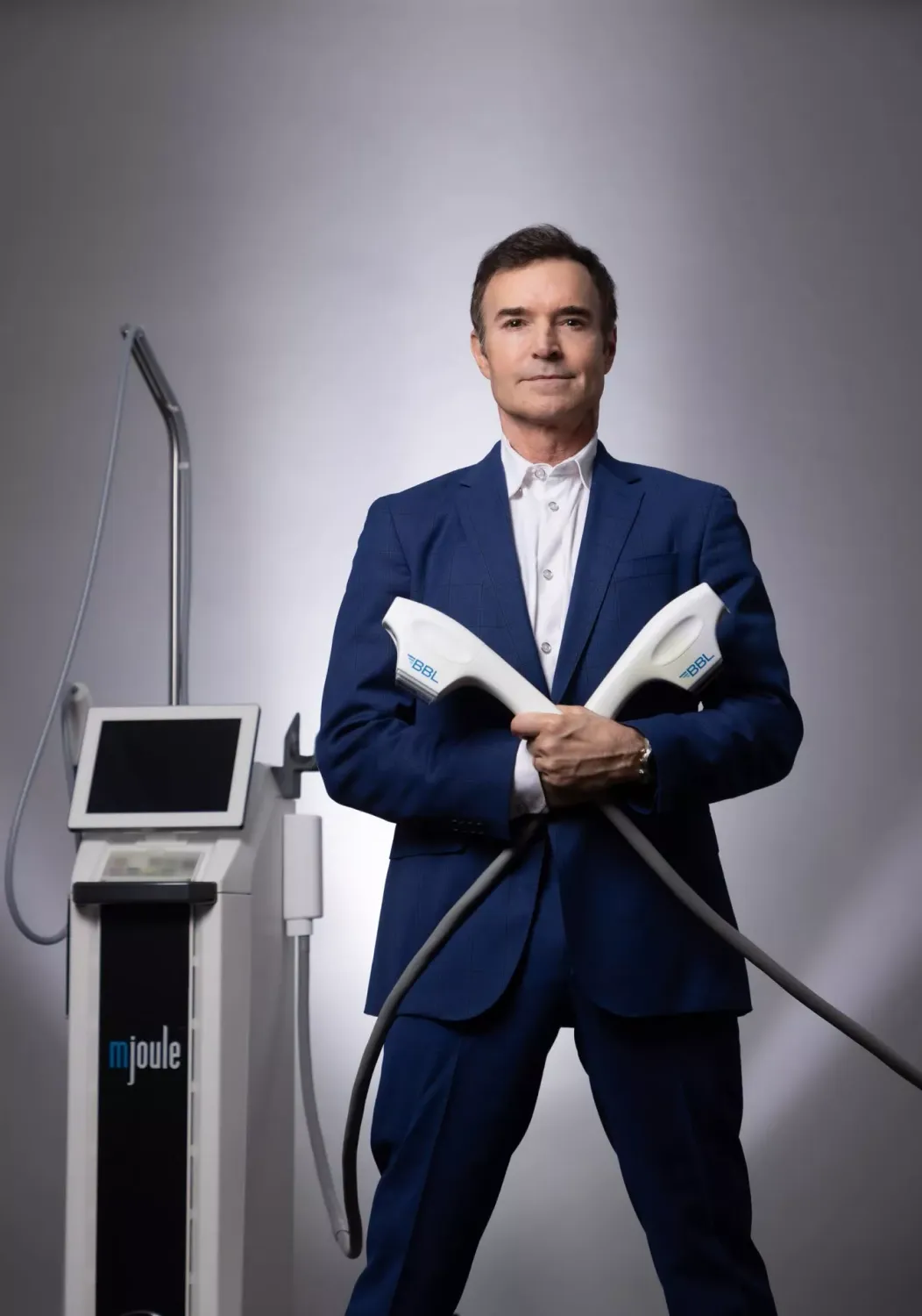 Man in suit holding medical equipment.