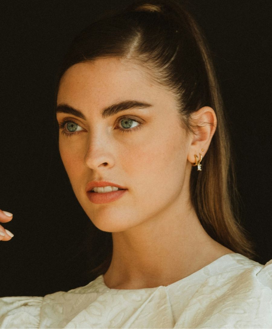 Woman with blue eyes and elegant white outfit.