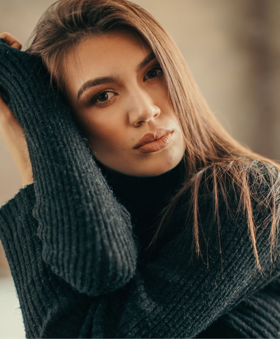 Woman in a black sweater with a thoughtful expression.