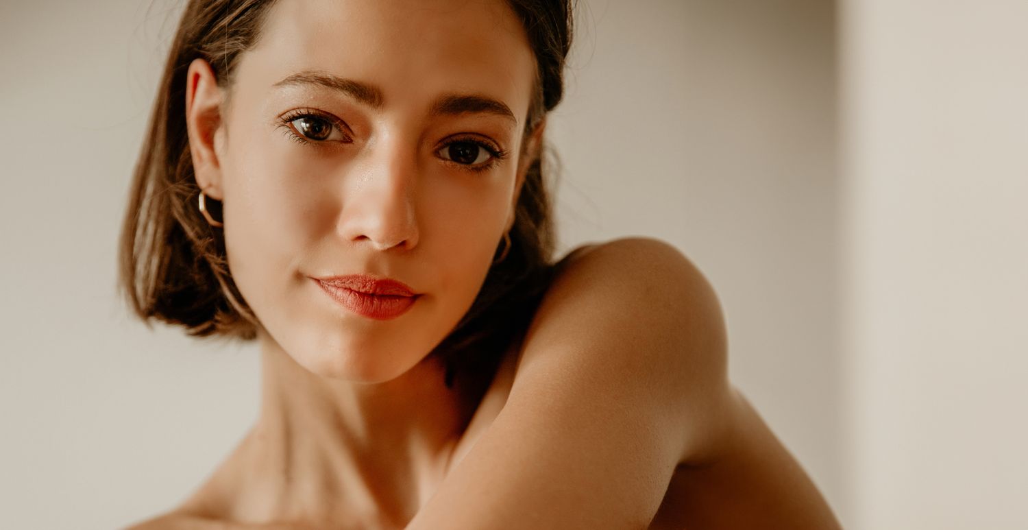 Woman with short hair posing thoughtfully indoors.