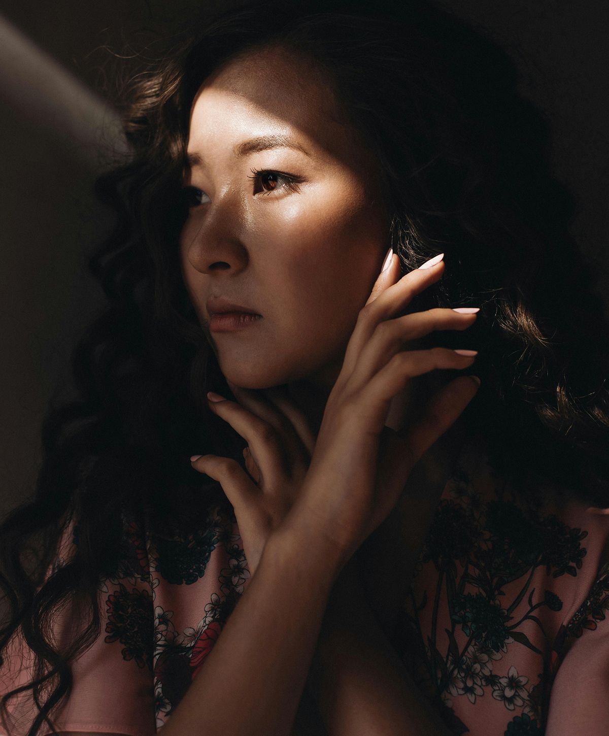Woman with curly hair in soft light.