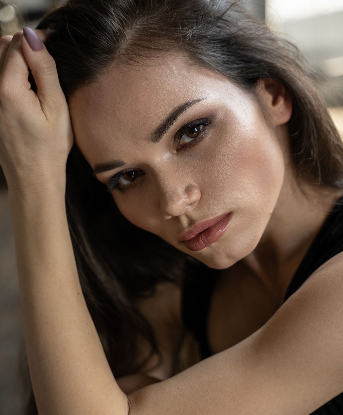 Close-up of a woman resting her chin on arm.