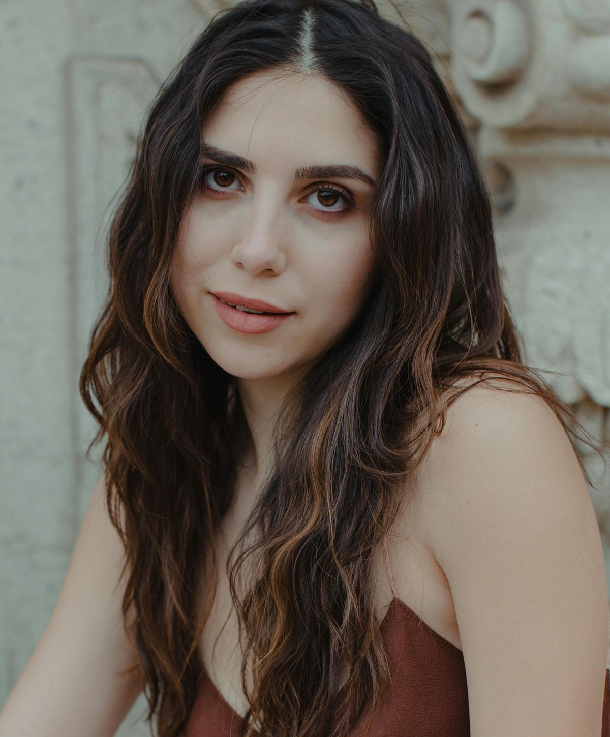 Young woman with wavy hair and soft expression.