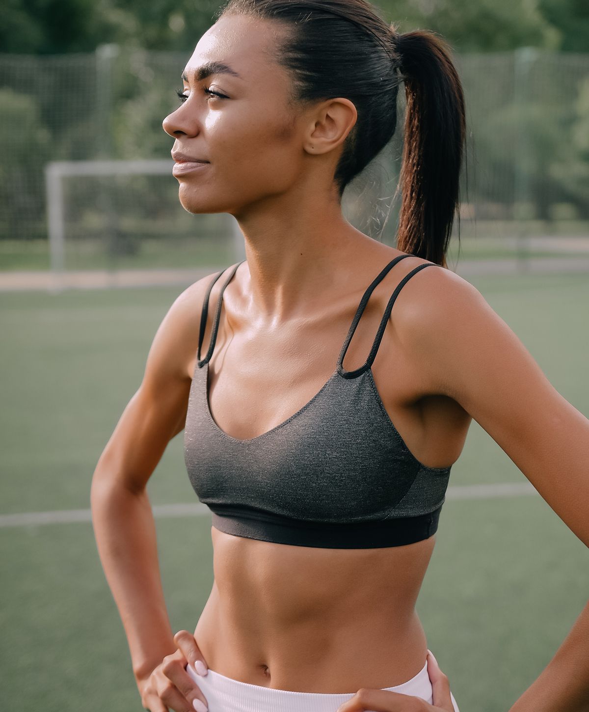 Fit woman in athletic wear on a field.