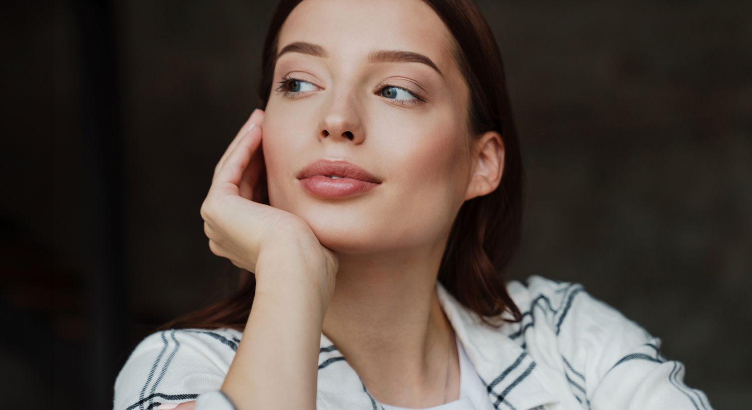 Thoughtful woman resting her chin on hand.