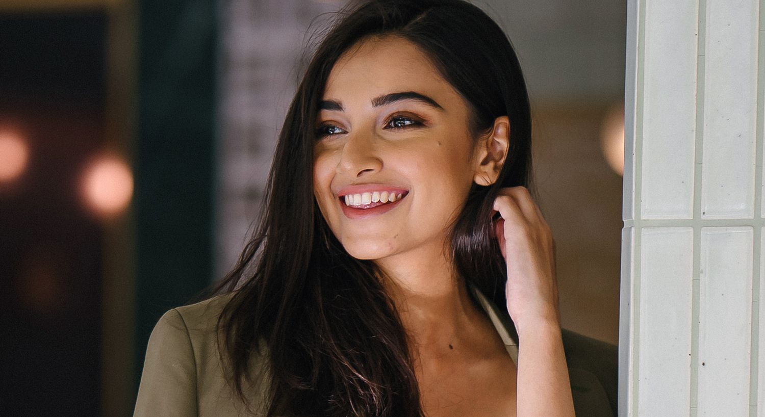 Smiling woman with long hair in a blazer.