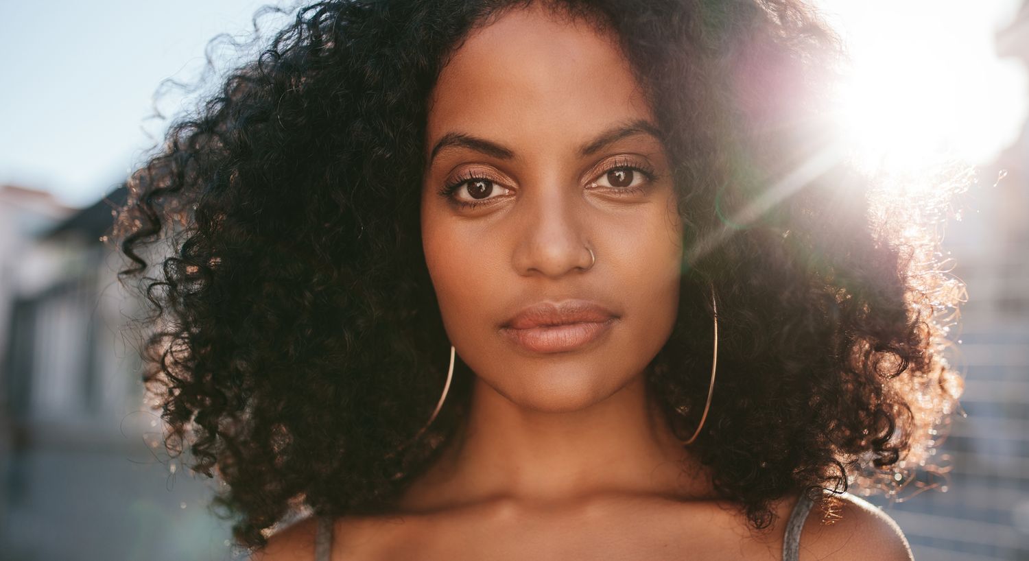 Woman with curly hair and natural makeup.