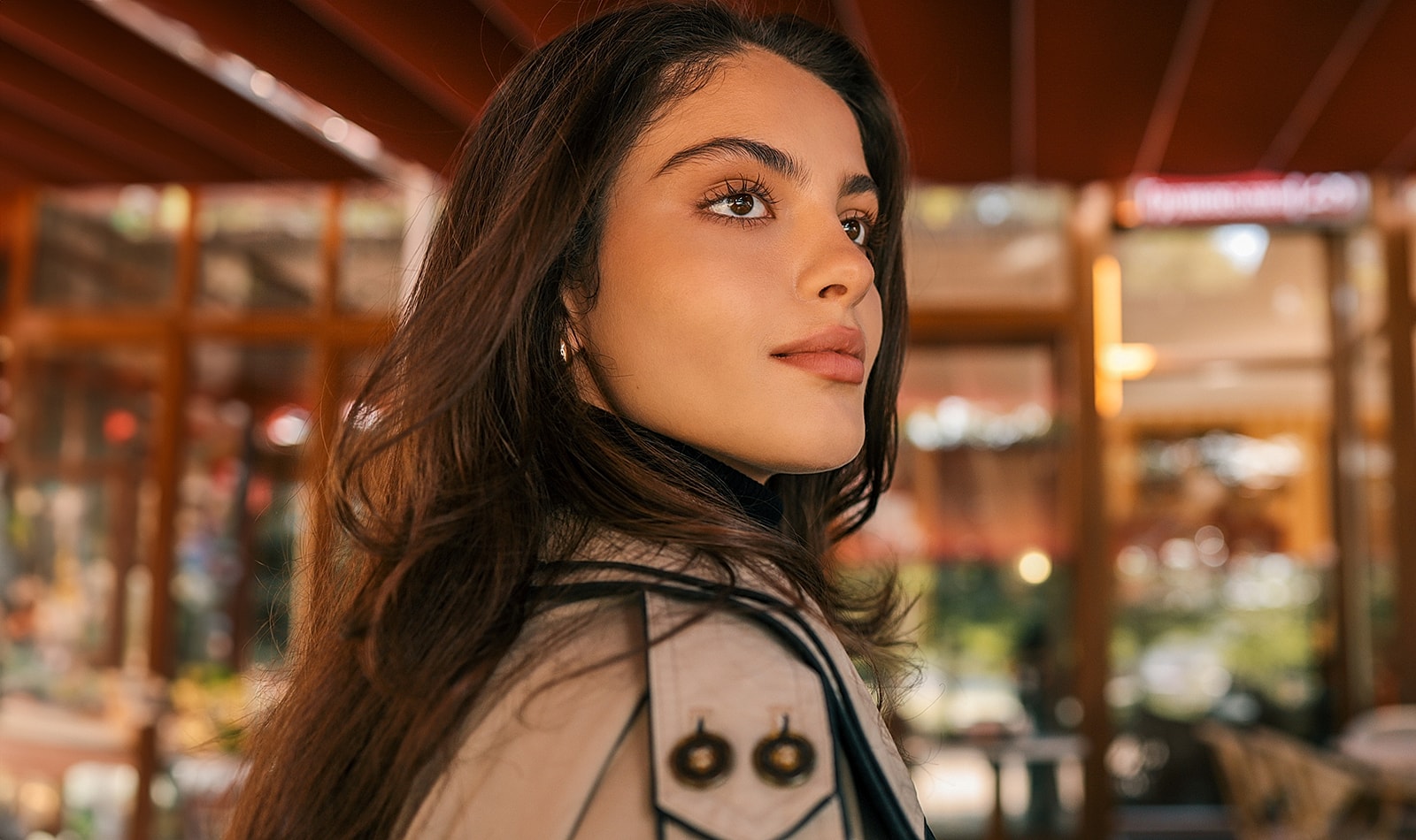 Woman with long hair in a café setting.